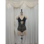 Black floral lace teddy on a mannequin, showing a deep V neckline, front cutout and scalloped lace edges