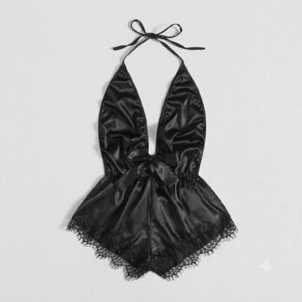 Black satin and intricate black eyelash lace halter teddy bodysuit lingerie with plunging V-neck and waist bow, flat lay product shot.