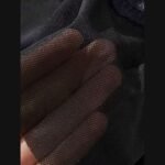 Sheer black mesh held over fingers to show its fine net texture and transparency